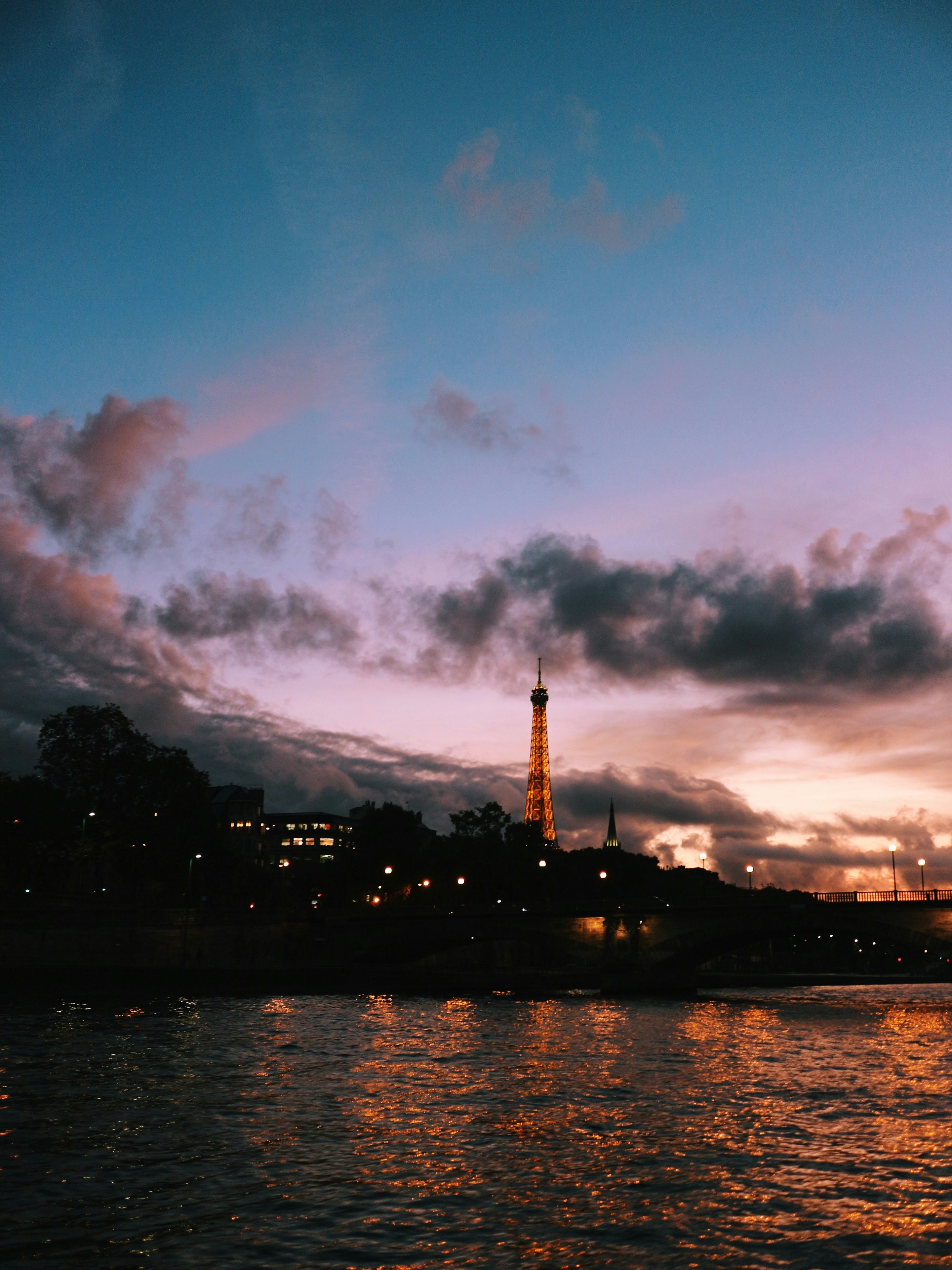 silhouette of building near body of water during sunset